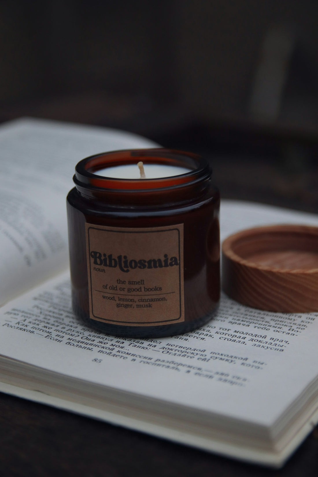 Gothic romantasy book flat-lay with a lit candle on a dark wooden table