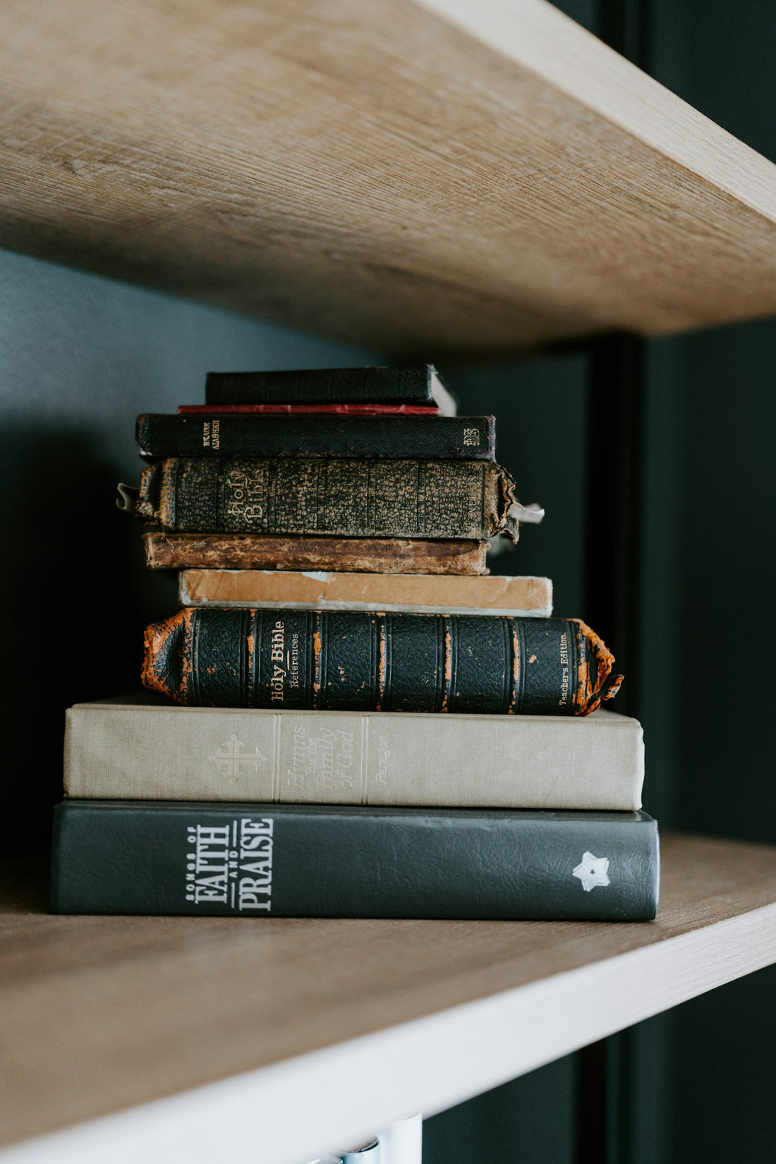 A warm, sunlit stack of books on a wooden shelf, evoking the reading life at the center of the banned books conversation